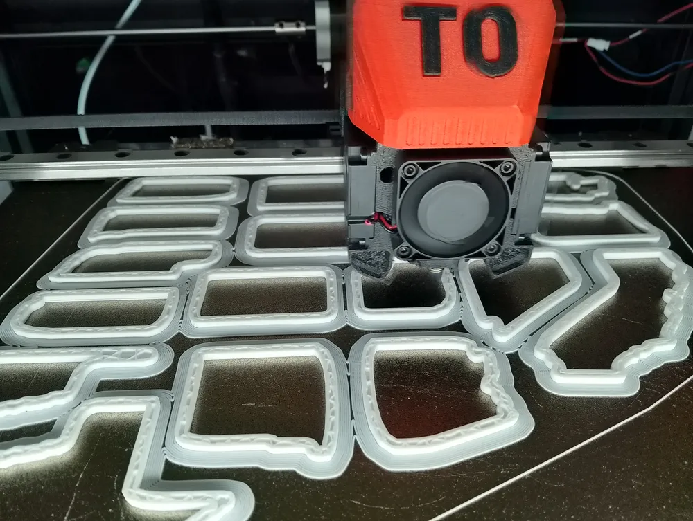 A 3D printer building cookie cutters in food-safe PLA